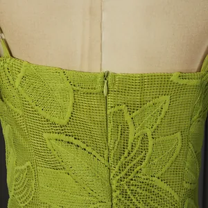 Detail view showing green embroidered leaf pattern and back zipper on a lace dress