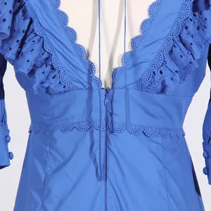 Close-up detail of a blue French dress featuring V-neck ruffles and eyelet embroidery