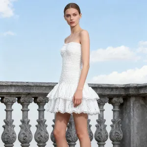 Vista detallada de un vestido blanco sin tirantes con bordados y volantes para vacaciones.