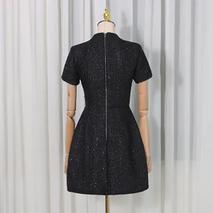 Vue arrière élégante d'une robe courte en tweed noir scintillant avec détail de fermeture