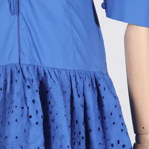 Close-up of blue eyelet embroidery and ruffled hem details of a French style dress