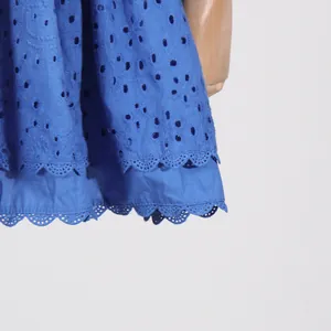 Close-up of blue eyelet lace fabric and layered scalloped hem for French style dress.