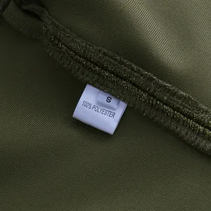 Detailaufnahme des Etiketts mit 100 % Polyester und Größe S auf grünem Stoff-Hintergrund.