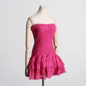 Detalle del vestido palabra de honor fucsia con bordado inglés y volantes
