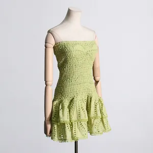 Detalle del vestido mini palabra de honor verde claro con bordados y volantes.