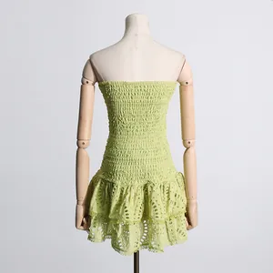 Vista trasera de un vestido palabra de honor verde claro con bordado y volantes bajos