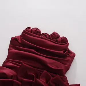 Close-up of wine red strapless dress featuring elegant 3D fabric roses and pleats