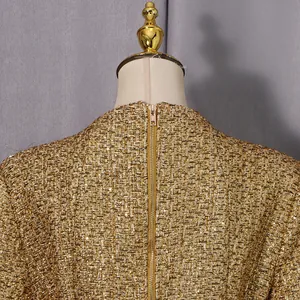 Gros plan sur la fermeture éclair arrière d'une robe en tweed doré de luxe au style vintage