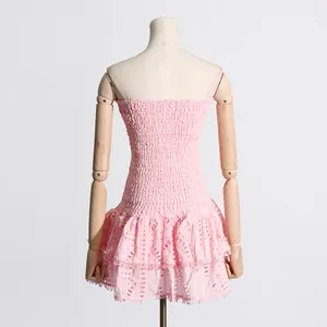 Vista trasera de un minivestido rosa sin tirantes con bordado inglés y volantes.