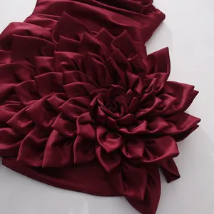 Close-up of wine red satin cocktail dress featuring intricate 3D fabric flower petals.