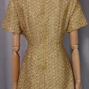 Détail du dos d'une robe rétro en tweed doré avec une longue fermeture éclair centrale