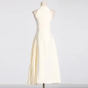 Back view of elegant white sleeveless dress with side pleated detail on mannequin