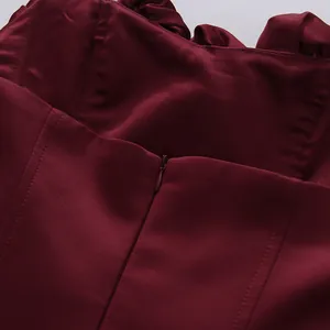 Close-up of burgundy evening dress with hidden zipper and delicate petal ruffles