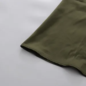 Detailaufnahme eines armee-grünen Saums mit präzisen Nähten und glatter Textur