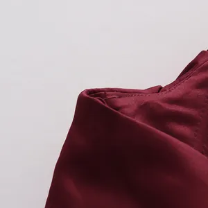 Macro view showing the high-quality stitching and satin fabric of the wine red evening dress