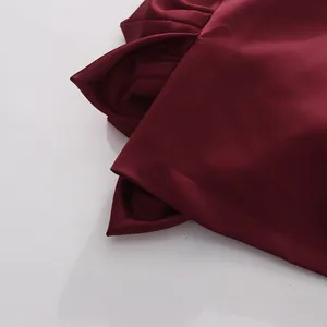 Close-up of wine red satin fabric showing elegant drape and floral petal details