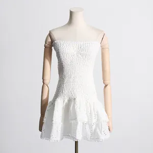 Vestido corto blanco palabra de honor con bordado inglés y detalles de volantes.