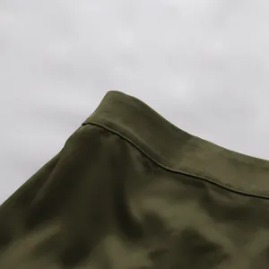 Nahaufnahme von olivgrünem Stoff mit hochwertigen Nähten an einem eleganten Rock