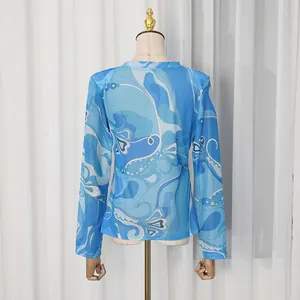 Back view of a retro blue swirl patterned long-sleeve lightweight top on a mannequin