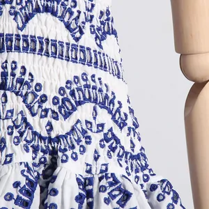 Detalle del bordado azul y el dobladillo con volantes en un vestido de playa