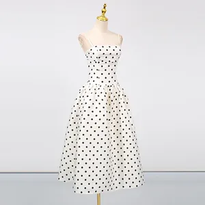 Elegante abito midi bianco in stile francese con pois neri esposto su un manichino