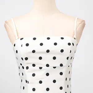 Vista dettagliata di un abito bianco elegante francese con stampa a pois neri a spalline