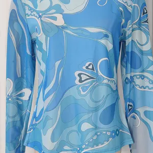 Detailed macro view showing the retro blue abstract floral print on mesh long-sleeved top