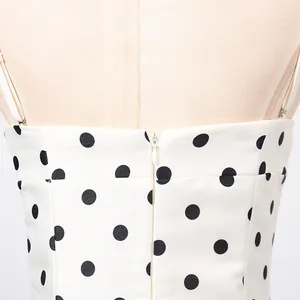 Dettaglio della cerniera invisibile sul retro di un abito bianco a pois con spalline