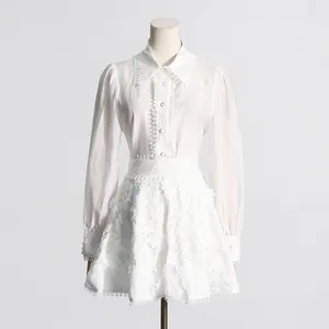 Elegante conjunto blanco de dos piezas con camisa de encaje y minifalda en maniquí.