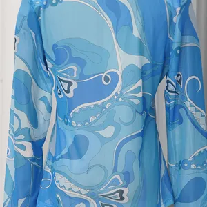 Close-up of vintage blue swirl pattern on long-sleeved lightweight chiffon blouse detail view