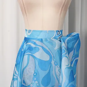 Detailed view of vintage blue satin skirt with abstract wave print and flowing silhouette.