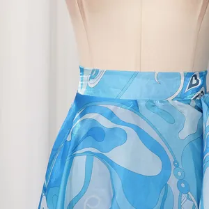 Close-up view of the detailed blue abstract print on a satin irregular skirt fabric