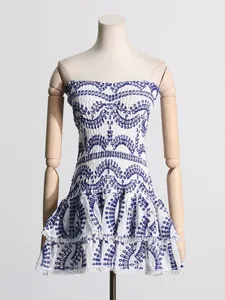Vestido corto playero blanco sin tirantes con bordado azul y dobladillo con volantes