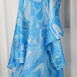 Detailed view of the blue abstract print pattern and satin fabric on this asymmetrical skirt