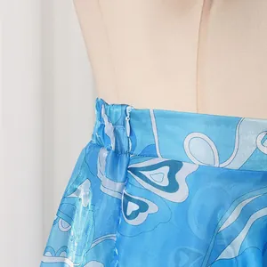 Detail of blue printed satin skirt showing invisible side zipper and waistband.