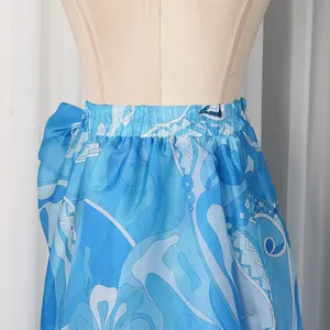 Detailed close-up of blue printed satin skirt with elastic waist and vibrant fabric texture.