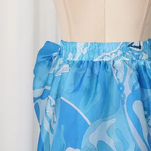 Detail view of a blue printed irregular skirt with elastic waist and satin finish