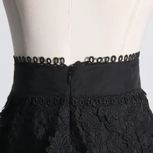 Primer plano de la cintura de falda de encaje negro con ribete y cremallera oculta.