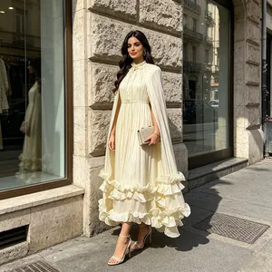 Elegante vestido largo plisado crema con capa a juego y detalles de volantes en el bajo.
