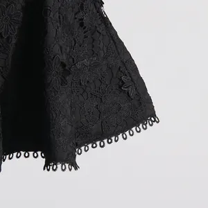 Primer plano de tela de encaje floral negro con detalle delicado de dobladillo