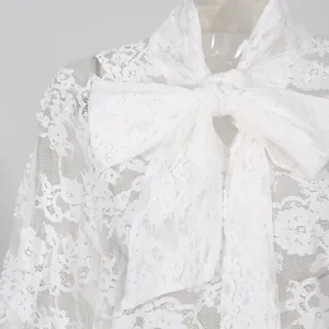 Dettaglio di una camicetta di pizzo bianco con un grande ed elegante fiocco per donna.
