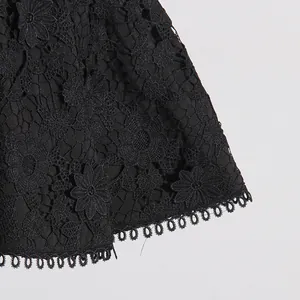 Primer plano detallado de encaje negro floral con un dobladillo festoneado decorativo.