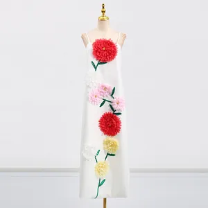 Detailansicht eines weißen Maxikleides mit lebendigen 3D-Blumenapplikationen und Trägern