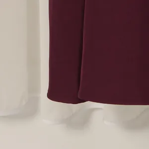 Nahaufnahme des Saums und des weißen Futters eines eleganten burgunderroten Abendkleids.