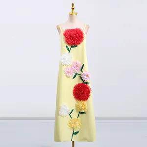 Detailansicht eines gelben Maxikleides mit lebendigen 3D-Blumenapplikationen auf Mannequin.