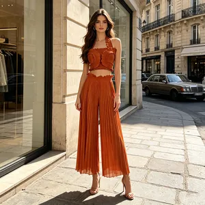 Full view of orange pleated two-piece set with halter top and wide-leg trousers
