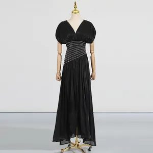 Elegantes schwarzes Maxikleid aus Satin mit Falten und Pailletten-Taille auf Schaufensterpuppe