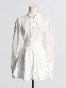 Elegante conjunto blanco de dos piezas con falda de encaje y blusa de manga larga