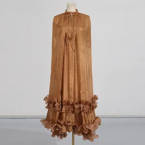 Primer plano de vestido de capa bronce metalizado con dobladillo volantes