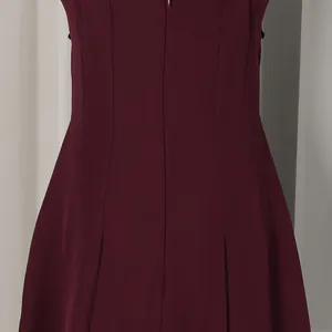 Detailansicht des Rückenreißverschlusses und der Falten an diesem eleganten weinroten Kleid.